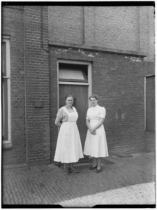 24227 FDSTORK-7316 Jonggezellenhuis Huize Insulinde . Opname van twee dames bij een buitendeur., 00-00-1950 - 00-00-1960