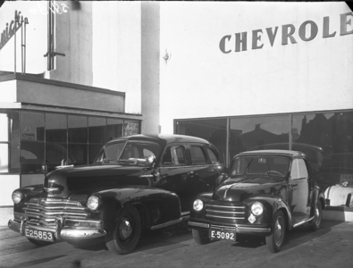 15696 FDHEEMAF058186 Kleine Fiat staande naast grote Chevrolet in de Chevrolet garage in Hengelo, 1951-02-06