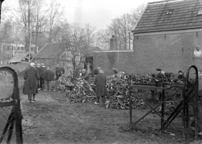 113 Wijhe: Opname in een tuin van een groep werkende mensen., 12-02-1941