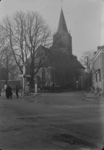 55 Goor: opname van de achterzijde van de Hofkerk, met voetgangers op straat en gevels van huizen in beeld. De kerk was ...