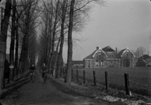 57 Goor: opname van fietsers op een landweggetje met bomen en een boerderij op de achtergrond., 1941-01-24