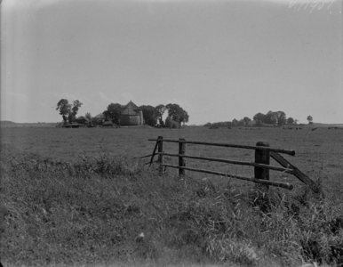 73 Opname op het Kampereiland, met een boerderij met hooischuren temidden van weilanden, 1935-07-19