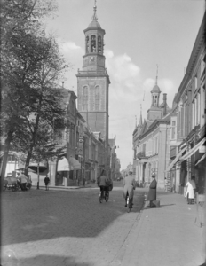 75 Kampen: opname in de Oudestraat met een kerk en het stadhuis en fietsers en voetgangers., 1936-10-09