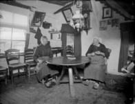 76 Markelo: opname van het interieur van leemboerderij 'De Eikenhof', met twee vrouwen die verstelwerk doen., 1935-10-25