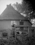 77 Markelo: Opname van een Twentse boerin bij een waterpomp, 1935-10-25