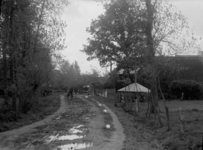 79 Markelo: opname van een landweg, met een boerderij met hooischuur op de achtergrond, en een fietser op de weg., 1938-06-03