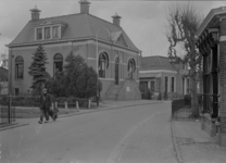 85 Olst: Opname van een straat in het dorp, met huizen en een man met kruiwagen., 1941-04-04