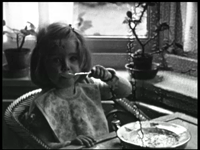 7906BB08059 Zeven familiefilmpjes van de familie Lamberts.5. IJsselstein (10-02):- Een meisje zittend in een kamer aan ...