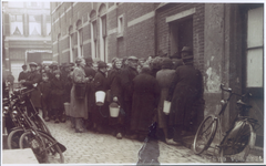 19762 FD029434 Mensen staan bij de ingang van slagerij Spruit in de binnenstad van Zwolle te wachten op een portie ...