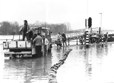 11248 Hoog water op de Welle nabij loopbrug naar het pontveer. Zandzakken worden gelegd door de Dienst Openbare ...