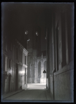 48 Stadsgezichten: Lebuinuskerk in het donker, gezien vanuit de Polstraat. Links Blokkers Administratiekantoor ...