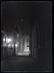 59 Stadsgezichten: Lebuinuskerk in het donker, de verlichte wijzers van de klok staan op kwart over acht. Gezien vanuit ...