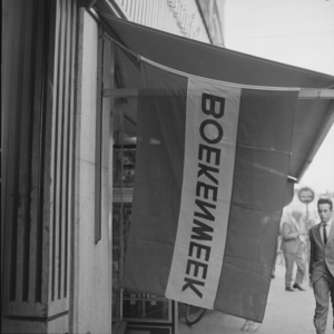 3211 De vlag van de Boekenweek hangt uit bij boekhandel Praamstra in de Lange Bisschopstraat., 1960-01-01