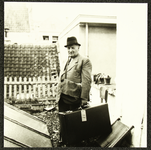 1290 Sam Noach in pak met hoed op en met een koffer in de hand, op een dakterras (foto-afdruk)