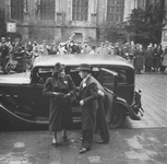 1309 Aankomst van bruiloftsgasten bij stadhuis te Deventer. Man en vrouw stappen uit de auto, chauffeur houdt het ...
