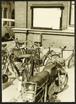 4864 Geparkeerde fietsen en bromfietsen in de Polstraat, bij een publicatiebord van de Gemeenten Deventer., 1974-01-01
