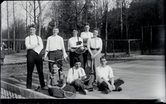 111 Groepsportret op de tennisbaan, van drie meisjes en vijf jongens, allen met tennisrackets in de hand, 1912-04-22