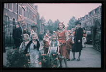 348 Bevrijdingsfeest mei 1945 in de Kromme Kerkstraat, met een kinderoptocht; kinderen zijn verkleed, vlaggen hangen ...