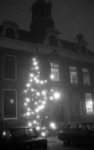 RJ000001118 December 1976EdamFoto 1/2: In de sfeervolle avondmist branden lichtjes in de kerstboom op de Dam tegenover ...