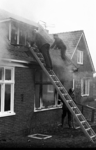 RJ000000314 Brandweer inspecteert de woning aan de Middenweg die zij zo goed als geblusd hebben. (NNC 15-01-1973)
