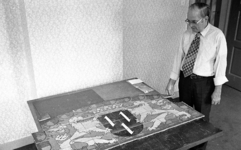 RJ000000914 Gemeentelijke archivaris Vree bekijkt het historische tegeltableau van het wapen van Purmerend. (NNC 26-07-1976)
