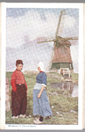 WAT001013285 Gezicht op de molen in de Volendammer polder.Er zijn een man en vrouw in Volendammer klederdracht te zien.