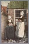 WAT001013321 Twee dames in Volendamse klederdracht voor een typisch huisje