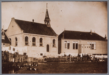 WAT001001938 Foto: De gereformeerde kerk (1889) en de oude christelijke school op Marken die op palen was gebouwd.De ...