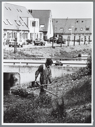 WAT001010316 Hovenier met een bosmaaier aan het werk in de Purmer-Noord.