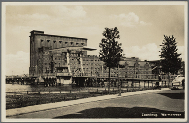 WAT002000042 De tweede Zaanbrug, met daarachter v.l.n.r.; ‘Silo’ ( ook wel ‘Oslo’ genoemd, gebouwd in 1905), pakhuis ...