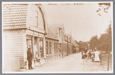 WAT002000789 Willem Hartog (1886) voor zijn Manufacturenwinkel (Dorpsstraat nummer 85) en daarnaast boekhandel Kuijper ...