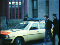 5022BB07712 Een film met beelden van:- Een politieauto, agenten en twee arrestanten;- De twee worden het politiebureau ...