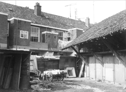 4667 FD000689 Achterzijde van bedrijfsruimtes met etagewoningen aan de Assiesstraat. De handkar en het wasgoed aan de ...