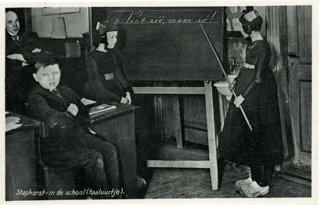 3587 PBKR6456 Gemengde schoolklas met links de meester en voor het bord twee meisjes in klederdracht. , 1930-00-00
