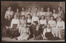 1037 Twintig vrouwen, leerlingen en lerares aan de Vrouwenarbeidschool, afdeling Kostuumnaaien, poseren. Afgedrukt als ...