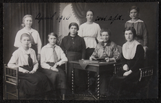 1060 Acht vrouwen, leerlingen en lerares aan de Vrouwenarbeidschool, Kostuumafdeling. Afgedrukt als ansichtkaart., 1918-04-01