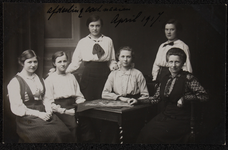1063 Zes vrouwen, leerlingen en lerares aan de Vrouwenarbeidschool, Afdeling Kostuumnaaien. Afgedrukt als ...