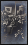 1079 Feestelijke foto van vrouw in stoel, omringd door bloemstukken. Naam achterop niet goed leesbaar (A Bengels?)., ...
