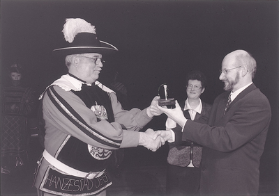 13809 Stadsomroeper Günther Kropp ontvangt de Deventer Promotieprijs 1997 uit handen van wethouder Martin Knol., 1997-01-06