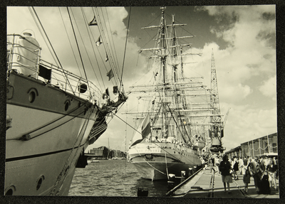 433 Zeilschepen aangemeerd in de haven van Amsterdam, waaronder Dar Pomorza . Publiek wandelt op de kade, 1961-01-01